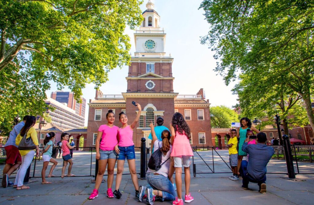A pair of young teen girls post in front of Independence Hall in Philadelphia.